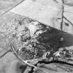 Oblique aerial view centred on the remains of the fort with the farmstead adjacent, taken from the ESE.