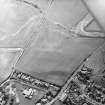 Oblique aerial view centred on the cropmarks of the possible ring-ditch, with the school adjacent, taken from the NNW.