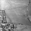 Oblique aerial view centred on the cropmarks of the possible ring-ditch, taken from the WNW.