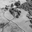Oblique aerial view of Shemore centred on the remains of the dun and a farmsteading, farmhouse and outbuildings, taken from the WNW.