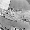 Oblique aerial view centred on the remains of the motte-and-bailey castle, taken from the SE.