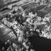 Oblique aerial view centred on the remains of the castle, chapel and tower, taken from the SE.