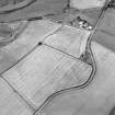 Oblique aerial view centred on the cropmarks of the Antonine Wall near Summerston Farm, taken from the NW.