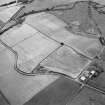 Oblique aerial view centred on the cropmarks of the Antonine Wall near Summerston Farm, taken from the SW.