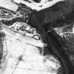 Oblique aerial view centred on the hunting lodge and ornamental gardens with the remains of a castle adjacent, taken from the NW.