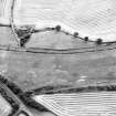 Oblique aerial view centred on the cropmarks of the E ring-ditch, taken from the N.
