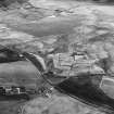 Haywood, Droveloan and Greenbank, oblique aerial view, taken from the NNW, showing Haywood village with the remains of miners' rows and a farmstead in the centre of the photograph, the two bings of a coal mine adjacent to the dismantled railway at the left edge, and areas of rig at Droveloan cottage in the top half, and Greenbank in the right centre.