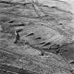 Levenseat Quarries, oblique aerial view, taken from the ENE, showing a dismantled railway curving across top right-hand corner, a group of spoil tips in the centre, and the remains of a series of tramways across the rest of the photograph.