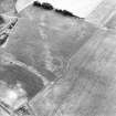 Oblique aerial view centred on the cropmarks of the field boundaries, pits and cropmarks with settlement adjacent, taken from the ESE.