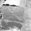 Oblique aerial view centred on the cropmarks of the field boundaries, pits and cropmarks with settlement adjacent, taken from the SE.