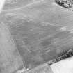 Oblique aerial view centred on the cropmarks of the settlement and further cropmarks, taken from the NNW.