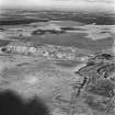 Tarbrax Shale-Oil Works, oblique aerial view, taken from the SSW, showing both massive shale bings of the shale-oil mine in the centre of the photograph. A tramway and the Tarbrax Branch of the Caledonian Railway both run across the centre of the photograph.