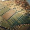 Oblique aerial view centred on the remains of the sheepfold, cairn and cist with the remains of the enclosure and scooped settlement adjacent, taken from the W.