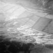 Oblique aerial view centred on the remains of the enclosure and scooped settlement with the remains of the sheepfold, cairn and cist adjacent, taken from the ENE.