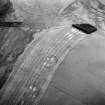 Oblique aerial view centred on the cropmarks of the fort, taken from the NNE.