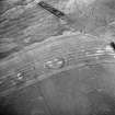 Oblique aerial view centred on the cropmarks of the fort, taken from the NNW.