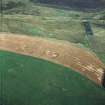 Oblique aerial view centred on the cropmarks of the fort, taken from the WNW.