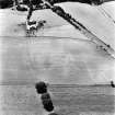 Bryland and Harestanes, oblique aerial view, taken from the NE, centred on the cropmarks of a possible enclosure. A linear cropmark is visible in the centre right of the photograph.