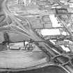 Oblique aerial view centred on the motorway interchange with the industrial estate adjacent, taken from the SSE.
