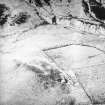 Oblique aerial view centred on the remains of the farmstead, rig, enclosures and quarry with sheepfolds adjacent, taken from the WSW.