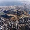 Oblique aerial view of Edinburgh centred on Holyrood Park, taken from the SW.