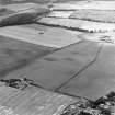 Oblique aerial view centred on the cropmarks of coal pits, taken from the NE.