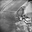 Oblique aerial view centred on the cropmarks of the enclosures, taken from the ESE.