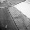Oblique aerial view centred on the cropmarks of the settlement with the cropmarks of the gravel pit adjacent, taken from the NW.