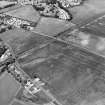 Oblique aerial view centred on the cropmarks of the cursus with the cropmarks of the field-system adjacent, taken from the SSW.