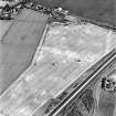 Westfield, Inveresk, oblique aerial view, taken from the SW, centred on the cropmarks of ditches of the W side of the cursus monument, crossed by the cropmark of a dismantled mineral railway.