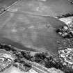 Brunstane, oblique aerial view, taken from the NW, centred on the cropmarks of an enclosure, coal pits and shaft, a possible enclosure and rig.  Other cropmarks are also visible. Brunstane House is visible in the right centre of the photograph.