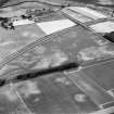 Monkton Lodge and Castlesteads, oblique aerial view, taken from the SSE, centred on a series of linear cropmarks and pits. Cropmarks of two pit-alignments are visible in the bottom half of the photograph.