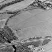 Oblique aerial view centred on the cropmarks of the mineral railway and Roman temporary camp, taken from the SSE.