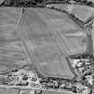 Oblique aerial view centred on the cropmarks of the mineral railway, cursus and Roman temporary camp, taken from the NE.