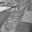 Howe Mire, oblique aerial view, taken from the SSW, showing the cropmarks of a series of coal pits in the bottom half of the photograph. Cropmarks of a settlement are visible in the centre.