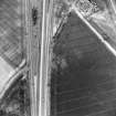 Oblique aerial view centred on the cropmarks of the ring-ditch, pits and rig, taken from the WSW.