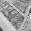 Oblique aerial view centred on the cropmarks of the palisaded settlement, roundhouses and pit-alignment, taken from the W.