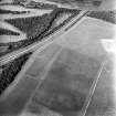 Oblique aerial view centred on the cropmarks of the palisaded enclosure, cropmarks, cultivation remains and possible ring-ditches, taken from the SSW.