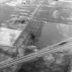 Oblique aerial view centred on the cropmarks of the coal-pits and field-boundary with other cropmarks including those of the settlement, the linear cropmarks, the ring-ditch, pits and rig adjacent adjacent, taken from the SSW.