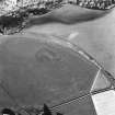 Oblique aerial view centred on the cropmarks of the enclosure with the enclosure adjacent, taken from the NW.