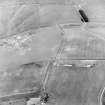 Oblique aerial view of Headshaw centred on the cropmarks of a fort, taken from the SSE.