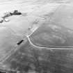 Oblique aerial view of Headshaw centred on the cropmarks of a fort, taken from the NE.