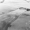 Oblique aerial view of Headshaw centred on the cropmarks of a fort, taken from the NW.