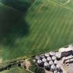 Oblique aerial view centred on the cropmarks of the fort with maltings adjacent, taken from the NE.