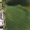 Oblique aerial view centred on the cropmarks of the fort with maltings adjacent, taken from the WNW.