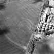 Oblique aerial view centred on the cropmarks of the fort with enclosure and maltings adjacent, taken from the E.