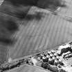 Oblique aerial view centred on the cropmarks of the fort with maltings adjacent, taken from the NE.