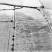 Oblique aerial view centred on the cropmarks of the settlement and enclosures, taken from the WSW.