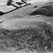 Oblique aerial view centred on the remains of the kerb cairn with rig adjacent, taken from the NW.