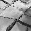 Oblique aerial view centred on the cropmarks of the settlement and trackway with field boundary adjacent, taken from the NNE.